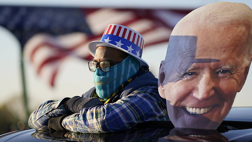 Ein Anhänger des Präsidentschaftskandidaten der Demokraten Biden schaut sich eine Wahlkampfveranstaltung von Joe Biden und und dem ehemaligen Präsidenten Barack Obama an.