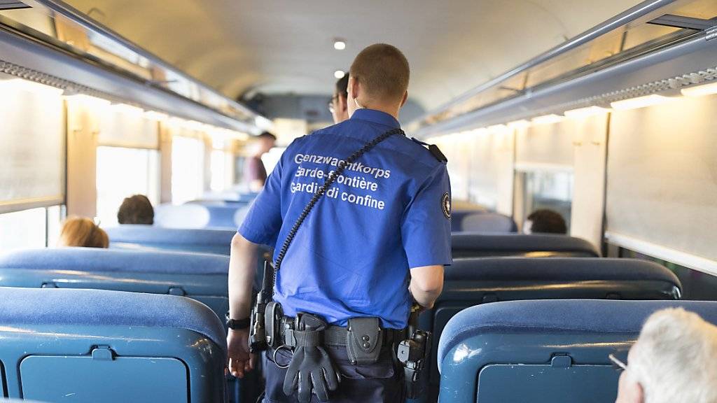 Kontrollieren nicht nur Reisende, sondern auch Bargeld: Schweizer Grenzwächter in einem Zug.