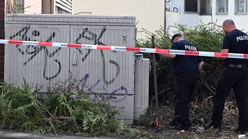 Polizisten suchen in der Innenstadt von Solingen in der Nähe eine gesperrten Unterführung nach Beweisstücken. Foto: Federico Gambarini/dpa