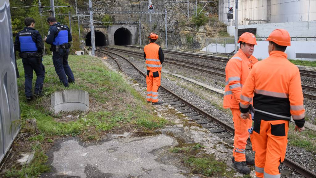 Polizisten und Bahnmitarbeiter in der Nähe des Ursprungs des Kabelbrands bei den Tunneln von Eclépens.