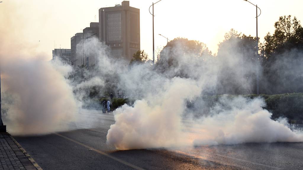 Polizisten in der pakistanischen Hauptstadt Islamabad feuern Tränengas auf Demonstranten ab. Foto: W.K. Yousafzai/AP/dpa