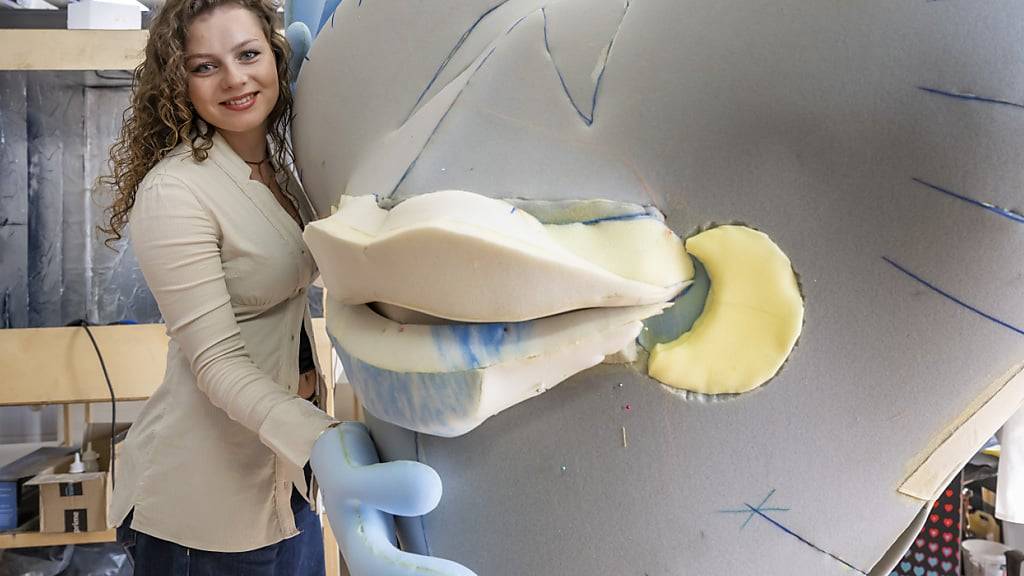 Die Kunststudentin Lynn Brunner nimmt im s'ander Atelier in Gelterkinden BL das von ihr entworfene ESC-Maskottchen Lumo in die Arme.