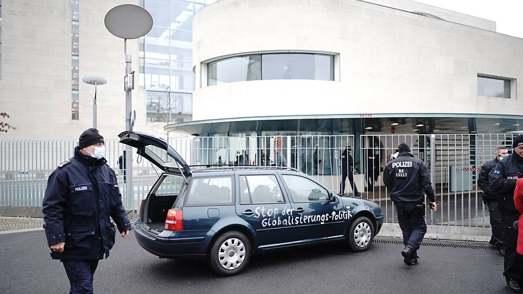dpatopbilder - Ein Auto steht vor dem Tor des Bundeskanzleramts. Auf der Tür ist die Aufschrift «Stop der Globalisierungs-Politik» zu lesen. Foto: Michael Kappeler/dpa