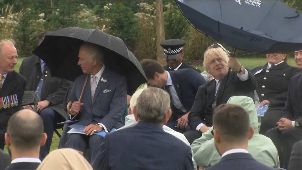 Hier kämpft Boris Johnson mit seinem Regenschirm