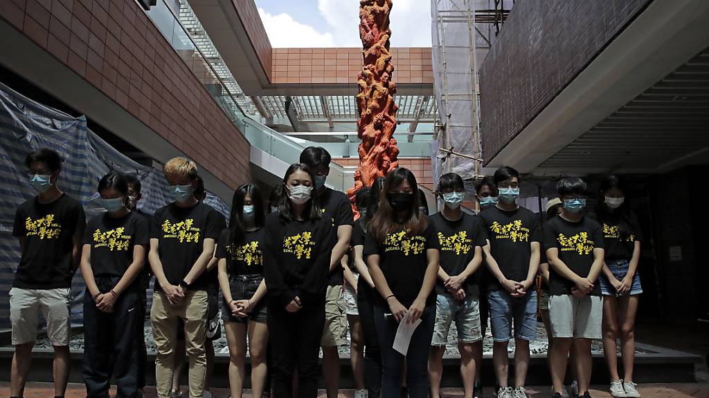 Studierende halten vor der Statue der «Säule der Schande» an der Universität Hongkong eine Schweigeminute, am Jahrestages der blutigen Niederschlagung der Demokratiebewegung am 4. Juni 1989 durch das Tiananmen-Regime in Peking. Foto: Kin Cheung/AP/dpa