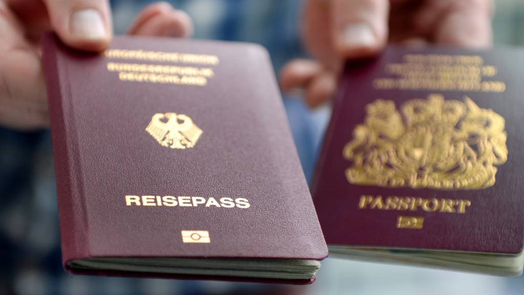 Ein britischer und ein deutscher Reisepass werden in die Kamera gehalten. Bis auf wenige Ausnahmen reicht ab dem 1. Oktober 2021 an ein Personalausweis nicht mehr aus, um in Grossbritannien zu kommen.