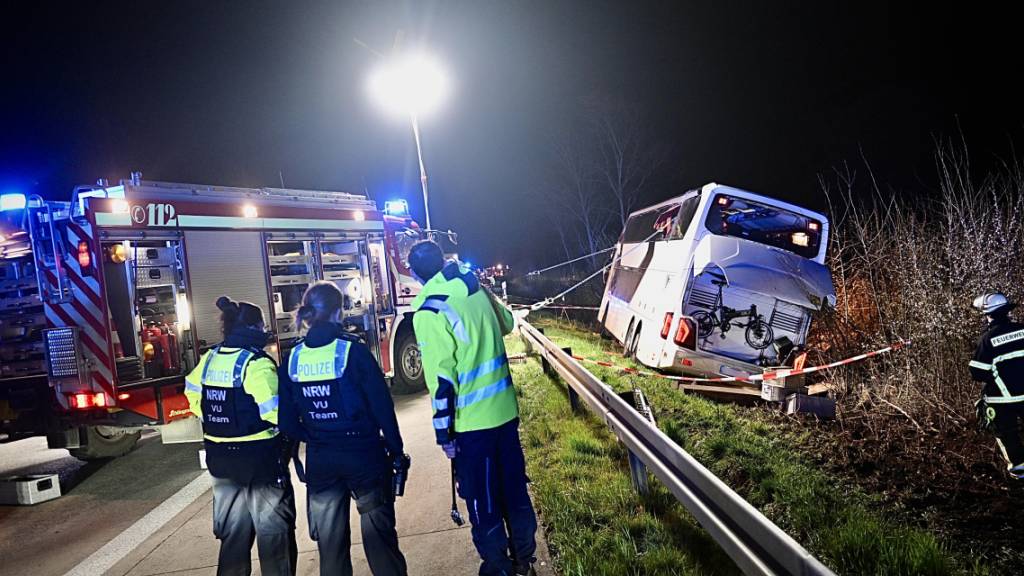 Einsatzkräfte der Feuerwehr und Polizei arbeiten an einer Unfallstelle auf der Autobahn 44 an einem verunfallten Bus. Foto: Daniel Schröder/dpa