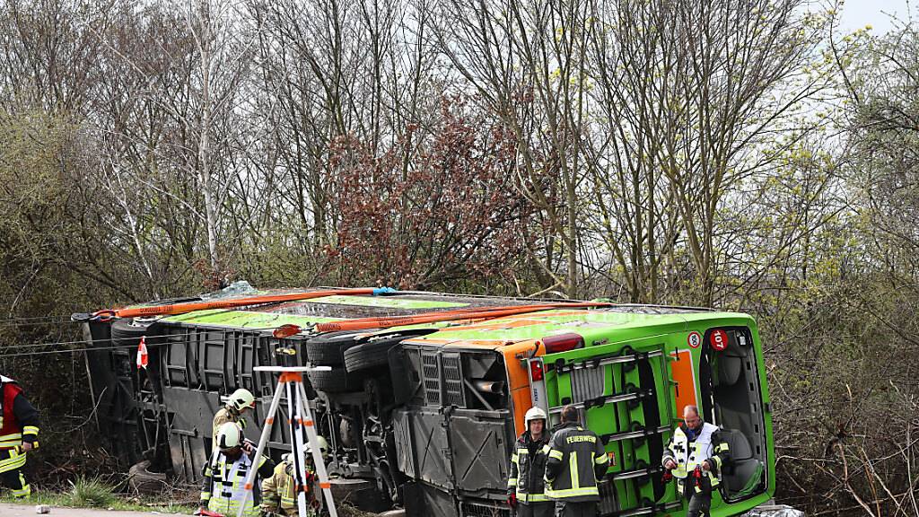 Ein Reisebus liegt zur Seite gekippt an der Unfallstelle auf der A9. Foto: Jan Woitas/dpa