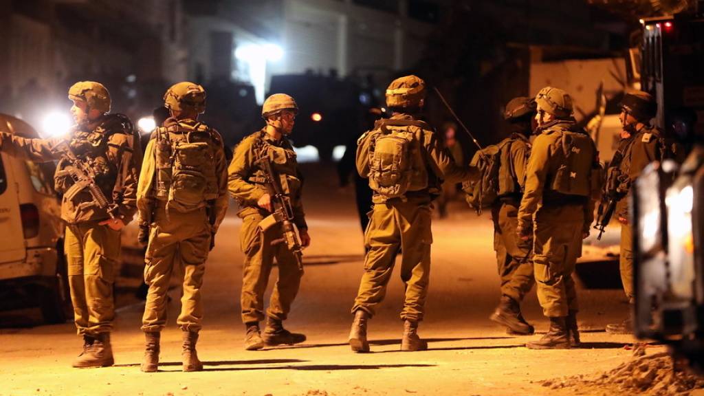 Israelische Soldaten bringen sich in der israelischen Siedlung Biet Kahel im besetzten Westjordanland in Position, während die Armee die Häuser der mutmasslichen palästinensichen Attentäter zerstört.