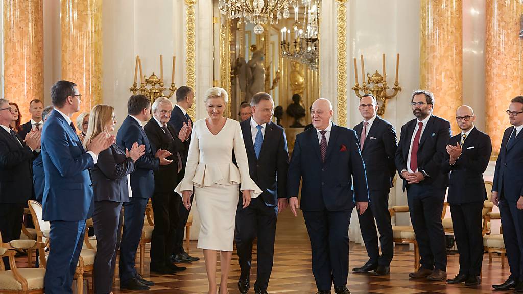 Andrzej Duda (M,r), Präsident von Polen, und seine Frau Agata Kornhauser-Duda (M,l), im Königlichen Schloss bei der Übergabezeremonie nach der Präsidentenwahl. Foto: Hubert Mathis/ZUMA Wire/dpa