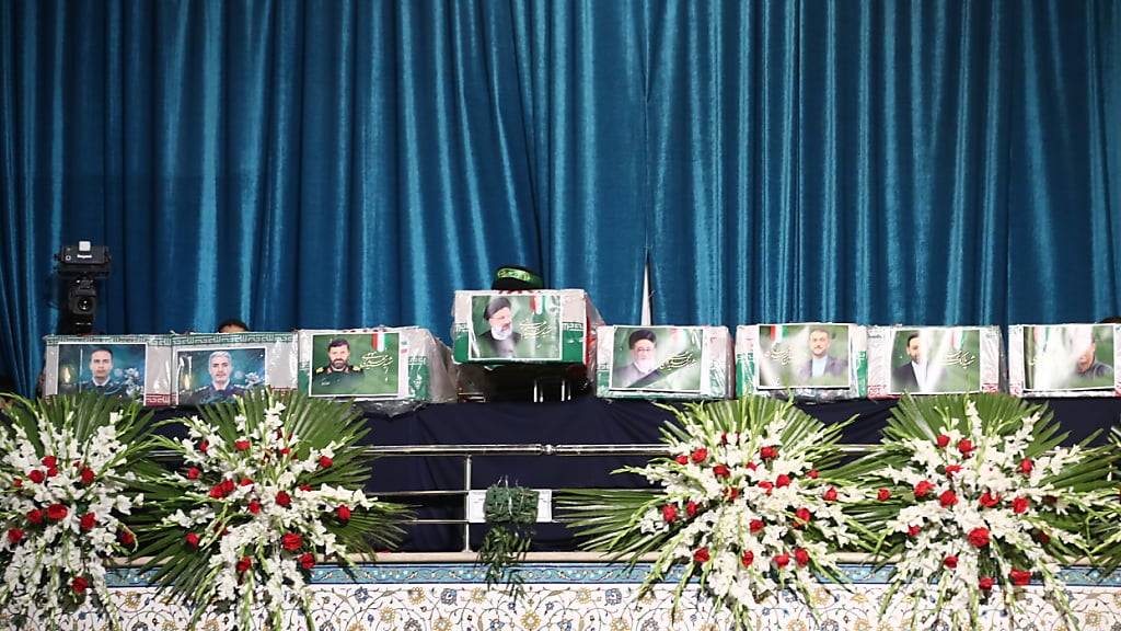 ARCHIV - Iranische Beamte richten die Särge vor einer Trauerfeier für den verstorbenen iranischen Präsidenten Ebrahim Raisi, Irans Außenminister Amirabdollahian und sieben weitere Tote im Schrein von Imam Khomeini. Foto: Saeid Zareian/dpa