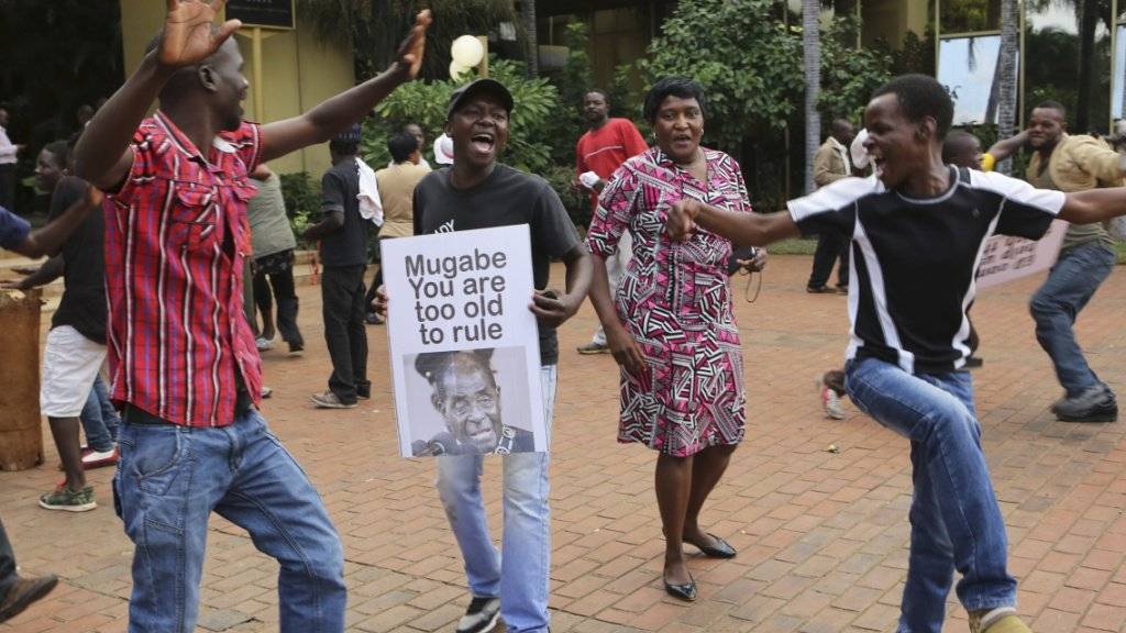 Menschen in Harare tanzen nach Mugabes Rücktritt auf den Strassen der Stadt.