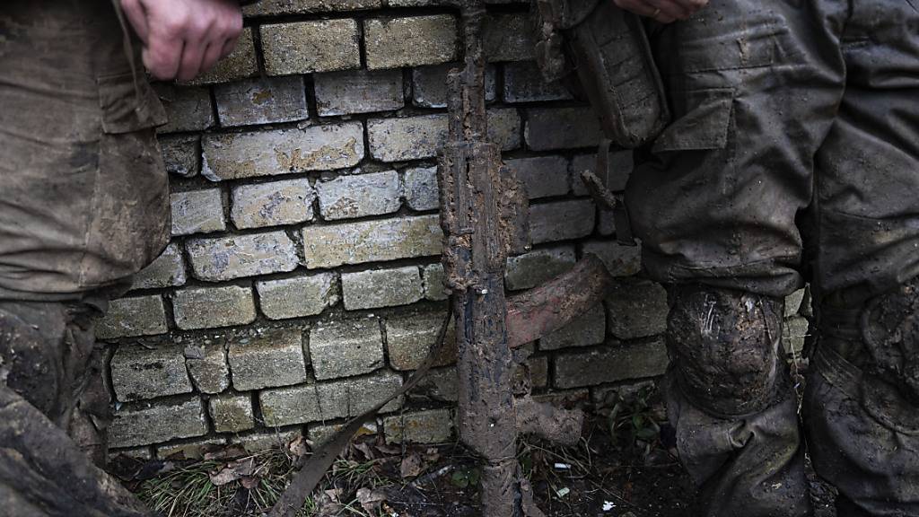 ARCHIV - Ein mit Schlamm verschmutztes Gewehr ist vor ukrainischen Soldaten zu sehen, die gerade von Schützengraben von Bachmut zurückkommen. Foto: Evgeniy Maloletka/AP