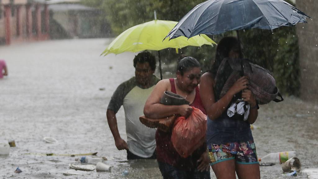 Menschen bringen sich in Sicherheit. Aufgrund des Tropensturms «Eta» wurden in Honduras Überschwemmungen und Erdrutsche gemeldet. Etwa 30 Ortschaften wurden von der Außenwelt abgeschnitten, weil Brücken einstürzten. Foto: Delmer Martinez/AP/dpa