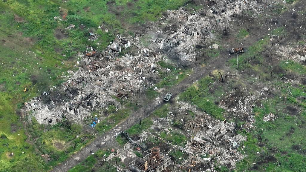 ARCHIV - Eine Luftaufnahme zeigt beschädigte Privathäusern, Granaten- und Raketenkratern in den Vororten von Donezk. Foto: Efrem Lukatsky/AP/dpa