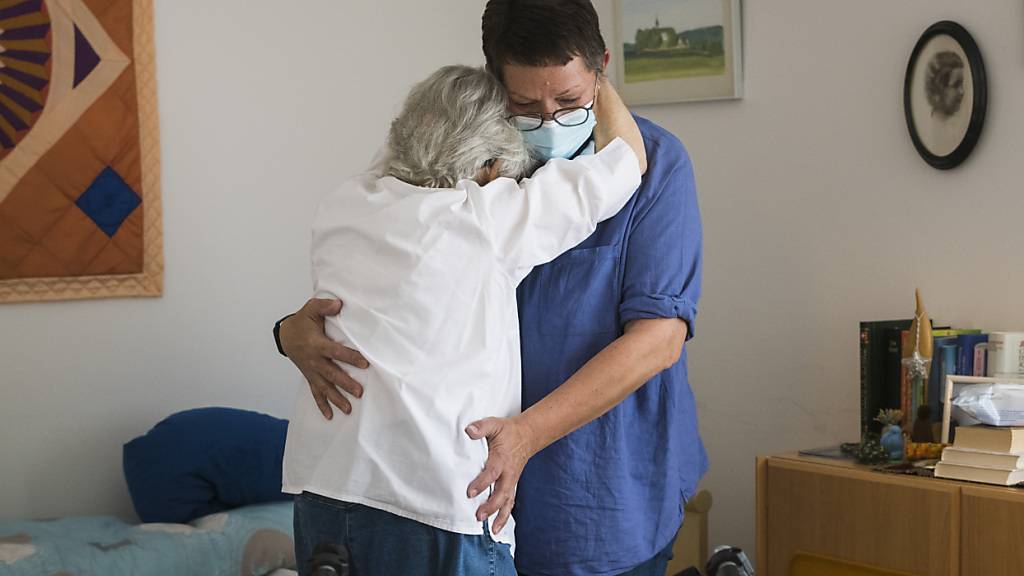 Eine Pflegefachfrau hebt mit speziellem Griff eine demenzkranke Bewohnerin vom Rollstuhl auf ihr Bett. (Archivbild)