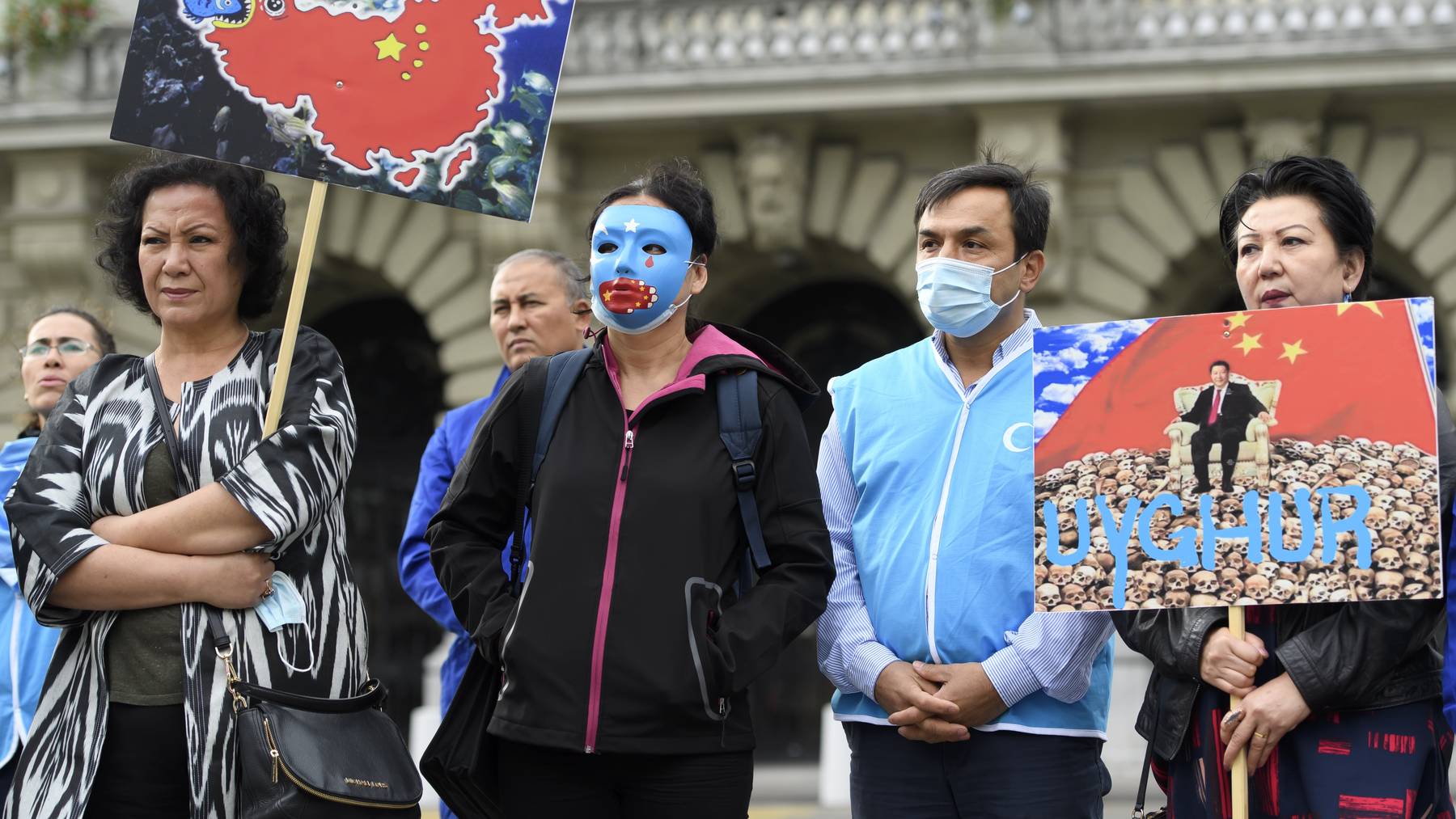 Personen mit Uiguren-Masken posieren auf dem Bundesplatz während der Einreichung der Petition «#NoComplicity: Schweiz muss Freihandelsabkommen mit China neu verhandeln!».