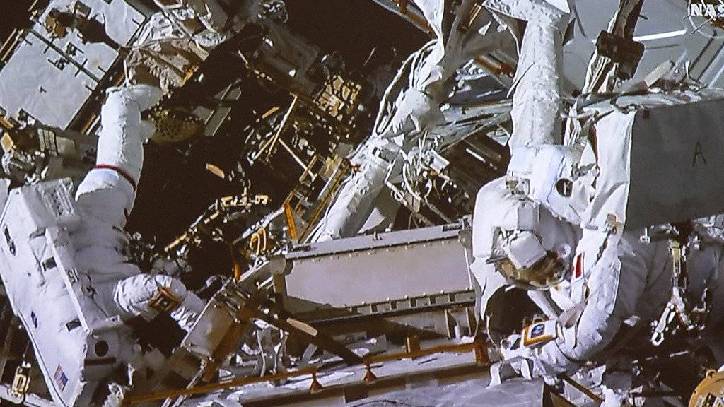 David Saint-Jacques (r,) und Anne McClain hangeln sich an der Aussenwand der ISS entlang.