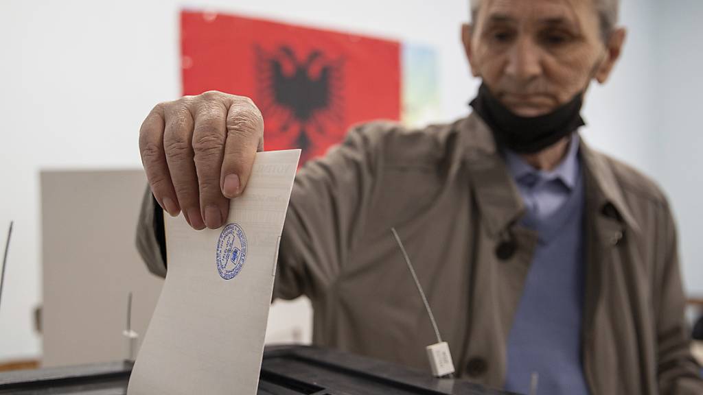 Eine Mann wirft seinen Stimmzettel in eine Wahlurne. Rund 3,6 Millionen Bürger sind dazu aufgerufen, ihre Stimme bei der Parlamentswahl in Albanien abzugeben. Foto: Visar Kryeziu/AP/dpa