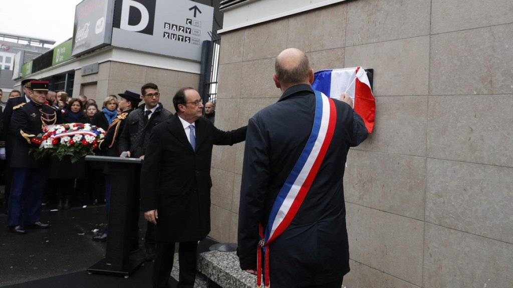 Frankreichs Präsident François Hollande (l.) und der Bürgermeister von Saint-Denis, Didier Paillard, enthüllen am Stade de France nördlich der Hauptstadt Paris eine Gedenkplakette.