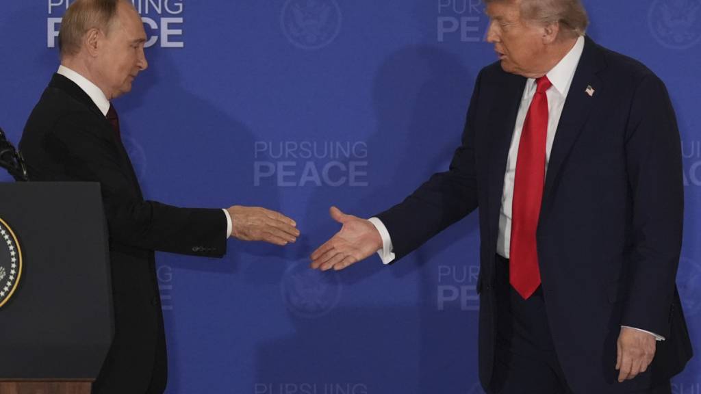 dpatopbilder - Präsident Donald Trump (r) reicht dem russischen Präsidenten Wladimir Putin während einer gemeinsamen Pressekonferenz auf der Joint Base Elmendorf-Richardson, Alaska, die Hand. Foto: Jae C. Hong/AP/dpa