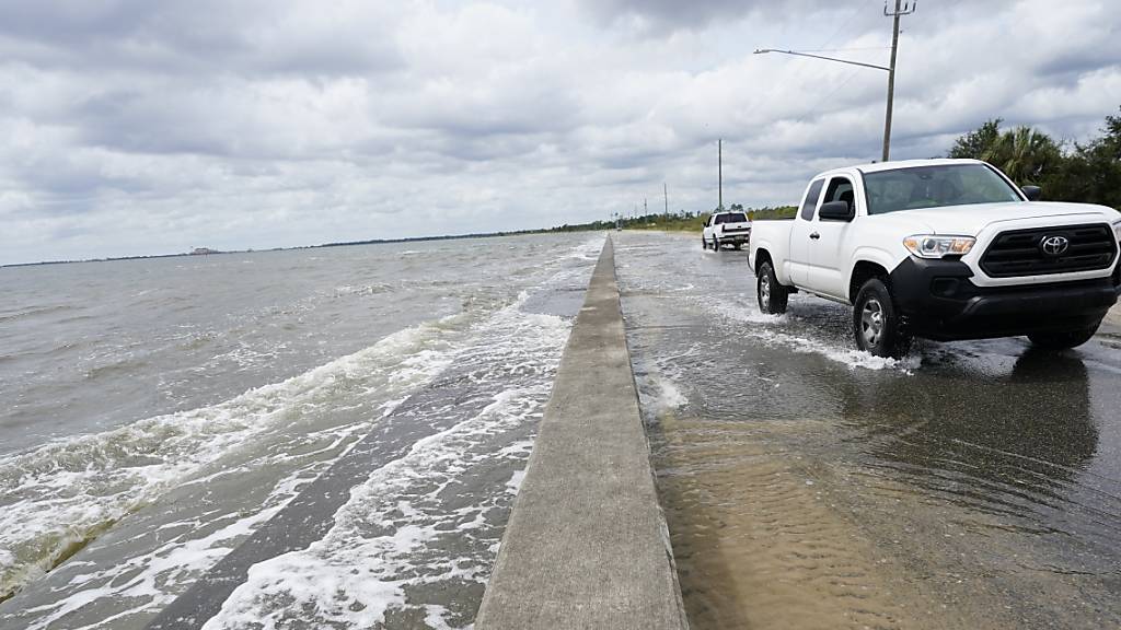 Ein Auto fährt über eine Straße, die durch den Tropensturm mit Meerwasser überflutet ist. Hurrikan «Sally» hat auf seinem Weg in Richtung der US-Golfküste weiter an Kraft gewonnen.