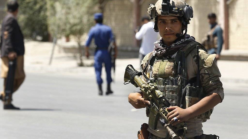 Ein Mitglied eines Spezialeinsatzkommandos sichert die Gegend nahe dem Präsidentenpalast in Kabul, wo es zu Raketenangriffen kam.