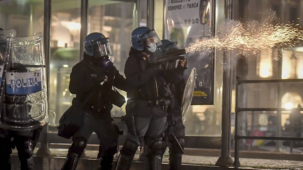 Polizisten setzen während eines Protests gegen die Corona-Maßnahmen der Regierung in Turin Tränengas ein. Foto: Claudio Furlan/LaPresse/AP/dpa
