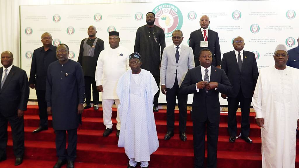 Omar Touray (l), Präsident der Ecowas-Kommission, begrüßt Nana Akufo-Addo (M), Präsident von Ghana, zum Ecowas-Treffen. Zwei Wochen nach der Machtübernahme des Militärs im Niger hat die westafrikanische Staatengemeinschaft Ecowas über das weitere Vorgehen gegen die Putschisten beraten. Foto: Gbemiga Olamikan/AP/dpa