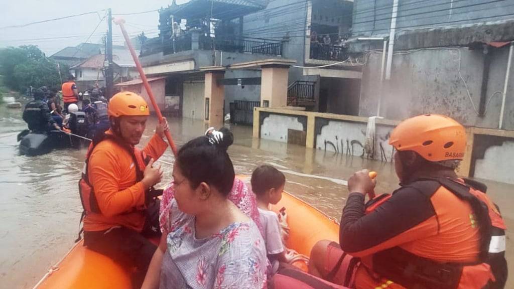 HANDOUT - Auf diesem von der Nationalen Such- und Rettungsbehörde Indonesiens (BASARNAS) via AP veröffentlichten Foto evakuieren Retter in einem Schlauchboot Bewohner aus ihrem überfluteten Haus in Denpasar, Bali. Foto: Uncredited/BASARNAS/AP/dpa - ACHTUNG: Nur zur redaktionellen Verwendung und nur mit vollständiger Nennung des vorstehenden Credits