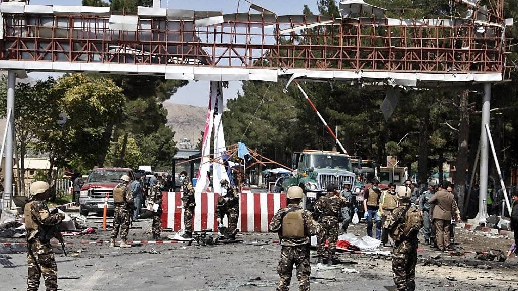 Ein Bild der Zerstörung: Afghanische Sicherheitskräfte inspizieren den Flughafeneingang von Kabul, wo sich ein Attentäter kurz zuvor in die Luft gesprengt hat.