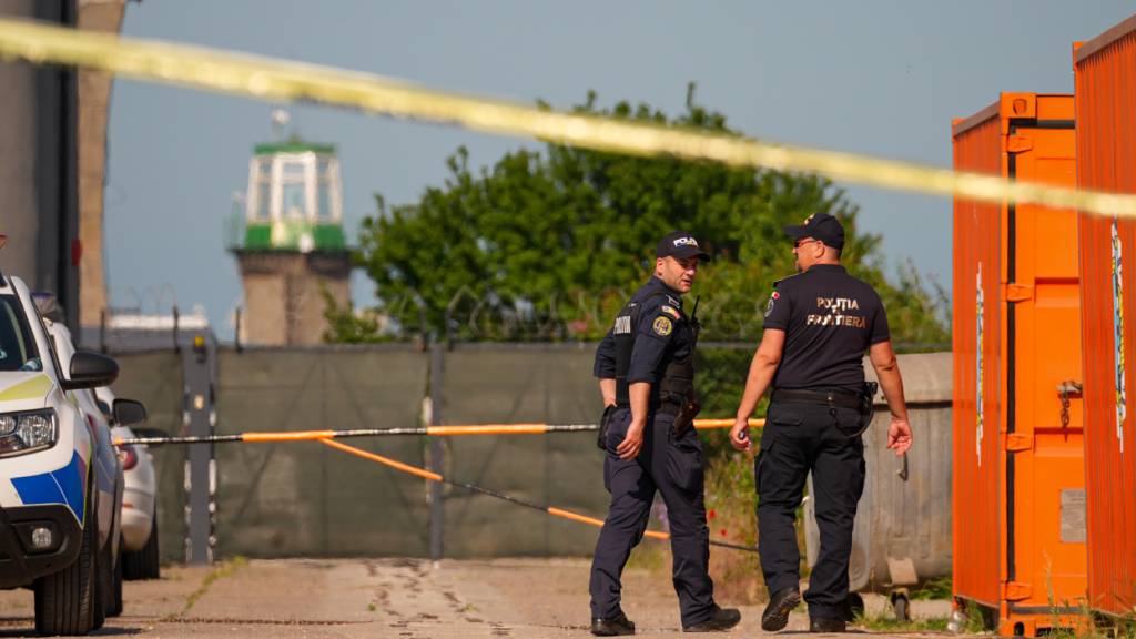 Rumänische Grenzpolizisten sichern einen Eingang in der Nähe eines beschädigten Lagerhauses nach der Explosion einer Drohne im Schwarzmeerhafen von Constanta. Foto: Vadim Ghirda/AP/dpa