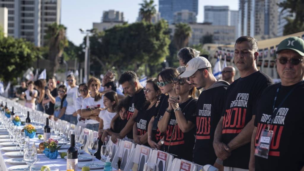 Angehörige von Menschen, die von Hamas-Kämpfern entführt wurden, beten in Tel Aviv umgeben von 203 leeren Stühlen. Foto: Petros Giannakouris/AP/dpa