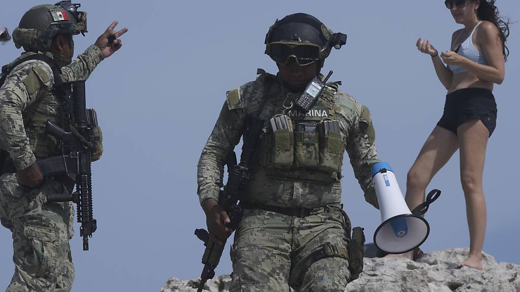 Soldaten bitten einen Touristen, den Strand Mirador vor der erwarteten Ankunft des Hurrikans Hurrikan «Beryl» zu evakuieren. Foto: Fernando Llano/AP/dpa