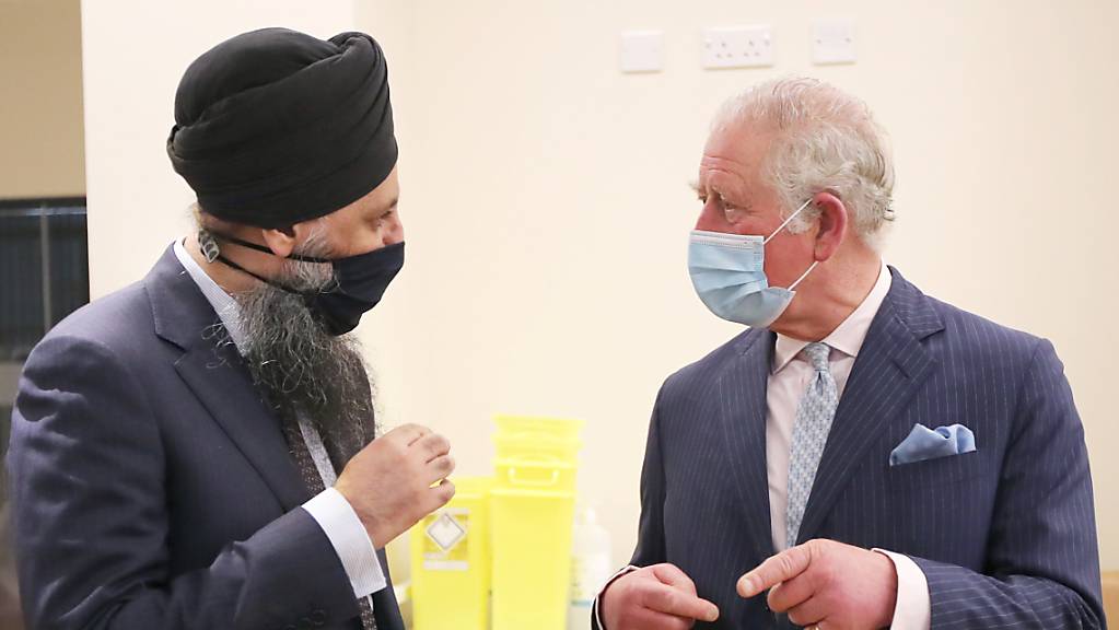 Der britische Prinz Charles (rechts), Prinz von Wales, unterhält sich mit Inderjit Singh, Chefapotheker, im Rahmen seines Besuchs im Queen Elizabeth Krankenhaus. Das Königspaar möchte sich bei den Freiwilligen bedanken, die an einer klinischen Studie für die Impfungen gegen das Coronavirus teilnehmen.