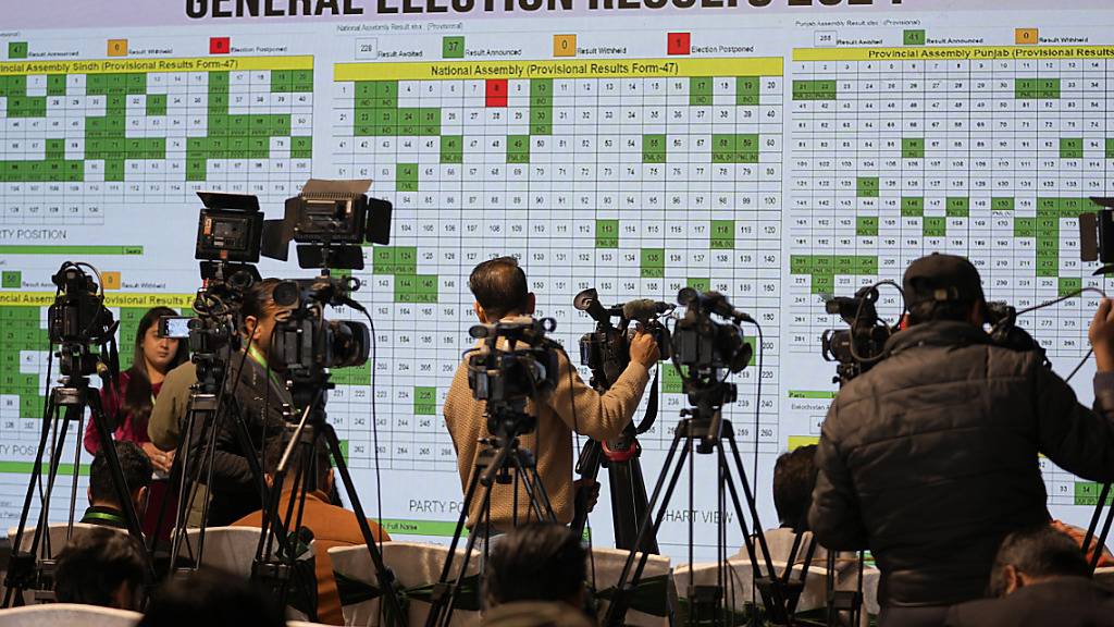 Fernsehteams vor einem Monitor, auf dem die Wahlergebnisse gezeigt werden. Foto: Anjum Naveed/AP/dpa