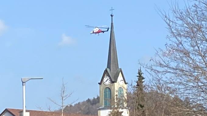 Helikopter über dem Dorf transportiert Bäume ab