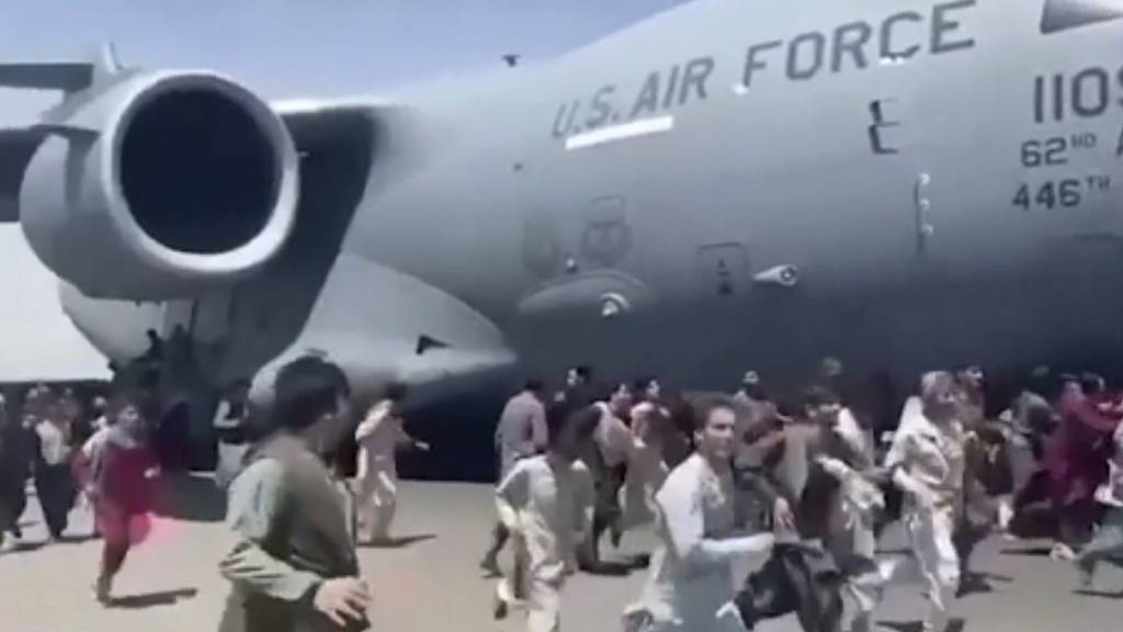 Verzweifelte Menschen rennen auf dem Flughafen von Kabul neben einer amerikanischen Militärmaschine her. Einige versuchten sich daran festzuhalten. Die US-Luftwaffe hat «menschliche Überreste» im Fahrwerkschacht der Maschine entdeckt.