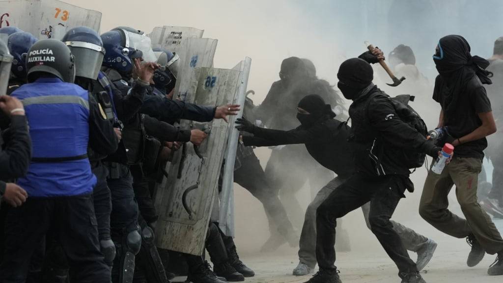 dpatopbilder - Demonstranten und Bereitschaftspolizei stehen sich während einer Demonstration gegenüber, bei der an den 57. Jahrestag der Eröffnung des Feuers auf protestierende Studenten auf der Tlatelolco Plaza im Jahr 1968 erinnert wird. Foto: Claudia Rosel/AP/dpa