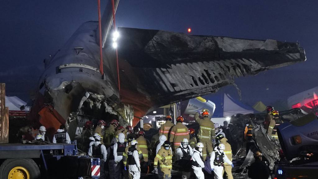 dpatopbilder - Rettungskräfte tragen die Leiche eines Passagiers. Foto: Ahn Young-joon/AP/dpa