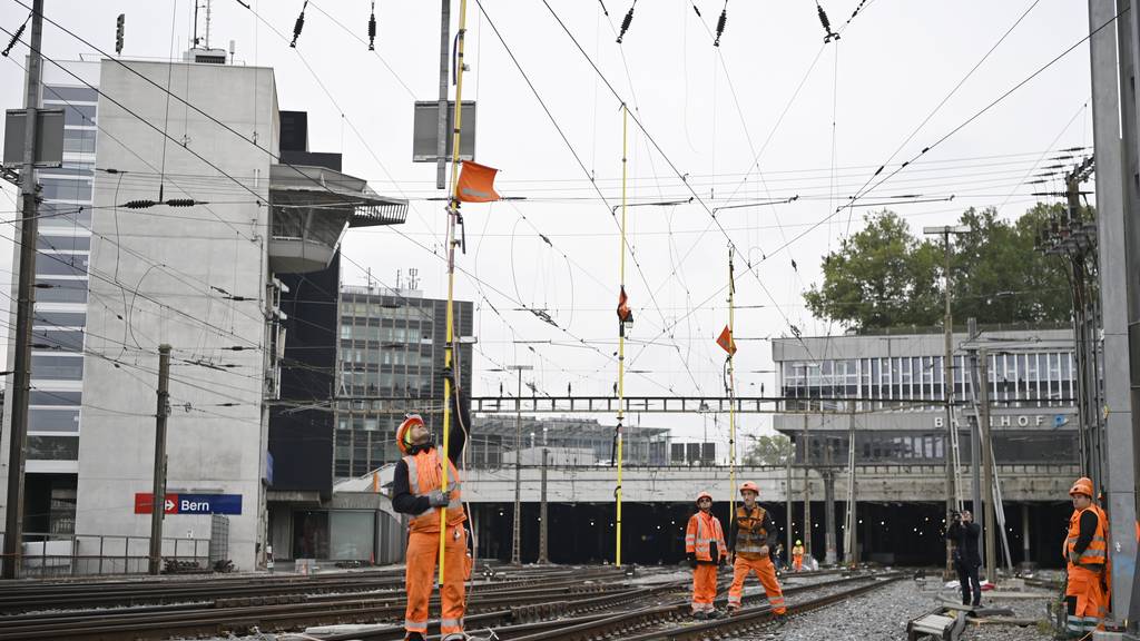 Bahnarbeiter reparieren die beschädigte Fahrleitung beim Bahnhof Bern.