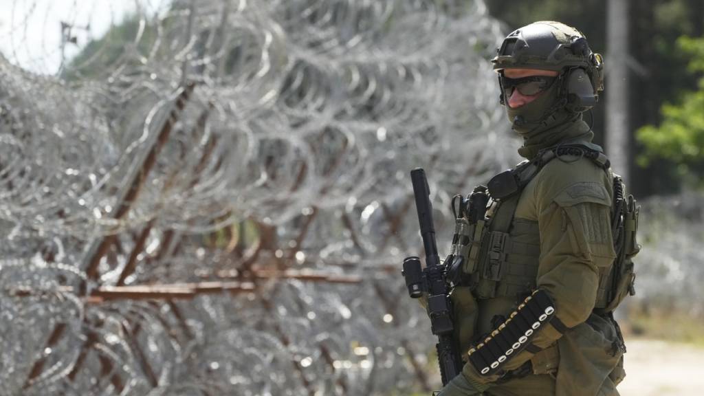 ARCHIV - Ein polnischer Grenzschutzbeamter steht an der polnisch-belarussischen Grenze. Foto: Czarek Sokolowski/AP/dpa/Archivbild
