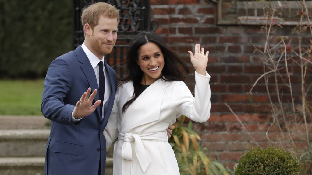 ARCHIV - Der britische Prinz Harry und die US-amerikanische Schauspielerin Meghan Markle winken nach Bekanntgabe ihrer Verlobung auf dem Gelände des Kensington Palace. Harry und Meghan sind nun zum zweiten Mal Eltern geworden. Foto: Matt Dunham/AP/dpa