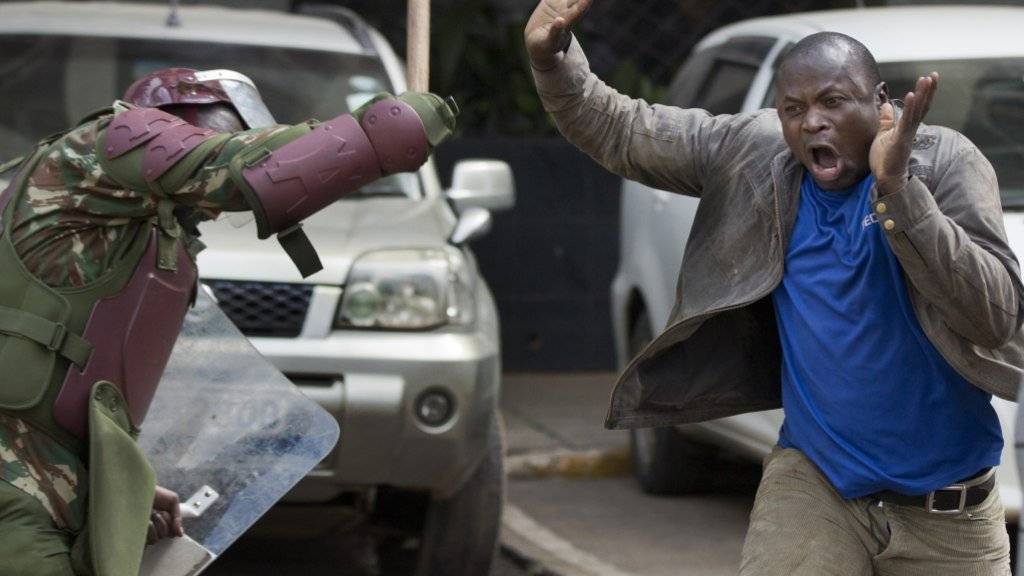 Ein Polizist schlägt einen Mann Holzknüppel während einer Demonstration der Opposition in Kenias Hauptstadt Nairobi.