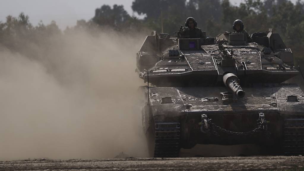Israelische Soldaten sind in der Nähe der Grenze zwischen Israel und Gaza mit einem Merkava Kampfpanzer unterwegs. Führende Menschenrechts- und Hilfsorganisationen rufen zu einem Stopp von Waffenlieferungen an Israel und bewaffnete Palästinenserorganisationen auf. Foto: Leo Correa/AP/dpa