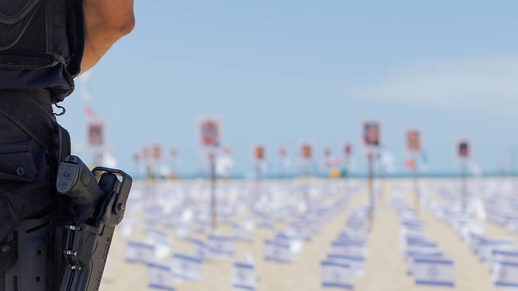 Ein bewaffneter Polizist steht Wache während einer Gedenkveranstaltung am Strand von Copacabana einen Monat nach dem Großangriff von Hamas auf Israel. Die Gedenkveranstaltung wurde von der brasilianischen NGO Rio de Paz organisiert. Foto: Joao Gabriel Alves/dpa