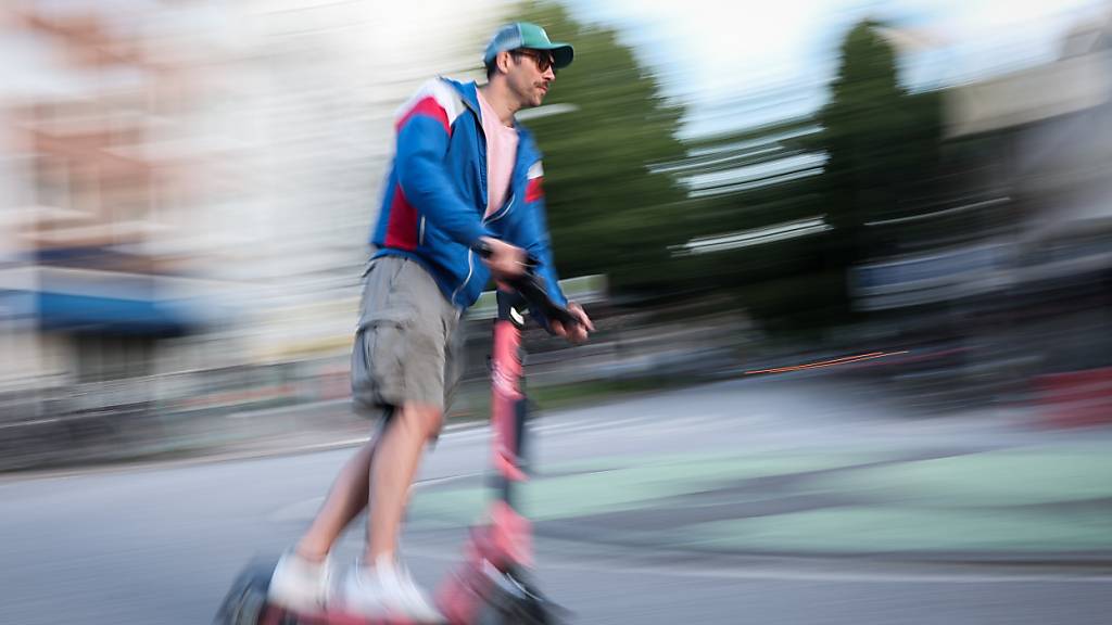 ARCHIV - Ein Mann ist auf einem E-Scooter unterwegs Foto: Christian Charisius/dpa