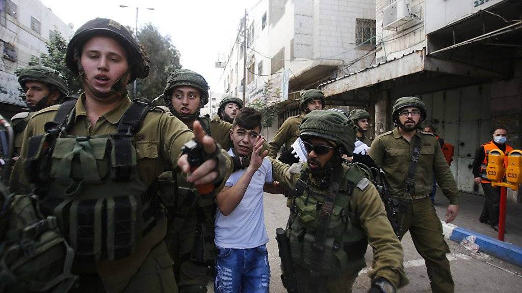 Israelische Soldaten nehmen in der Stadt Hebron im besetzten Westjordanland einen palästinensischen Knaben fest.
