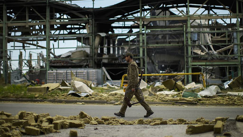 Ein ukrainischer Soldat geht an einer durch Beschuss zerstörten Gipsfabrik vorbei. Foto: Francisco Seco/AP/dpa