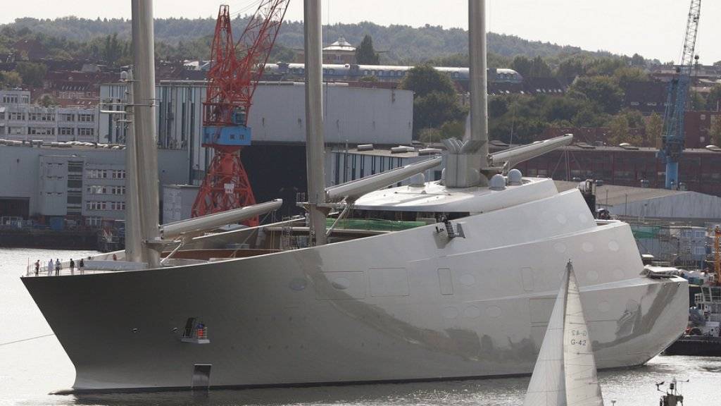 Die Segeljacht «Sailing Yacht A», wie sie am 16. September 2016 in Kiel für ein kurzes Wendemanöver aus dem Dock der Werft von Nobiskrug geschleppt wird, während ein Segelboot vorbeifährt.